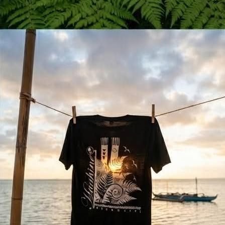 T-shirt noir suspendu au coucher du soleil, pirogue au loin