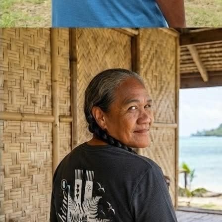 Grand-mère en t-shirt noir sous un fare en bambou